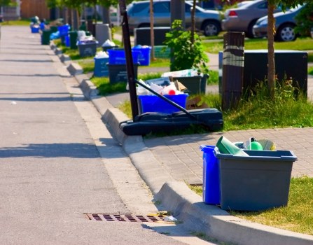 Crew setting up traffic management and signage around a skip